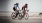 women bicycling on the road along a beach